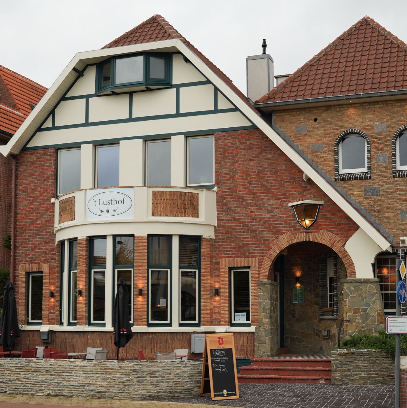 Dezelfde gevel vandaag, met het krijtbord op het terras