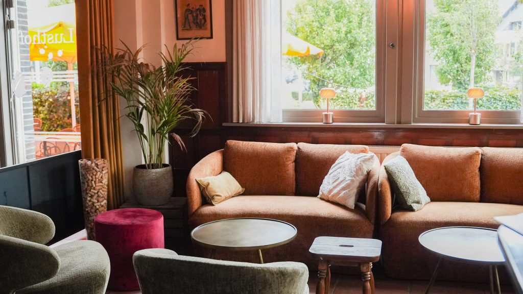 De zithoek met de oranje bank aan het raam
