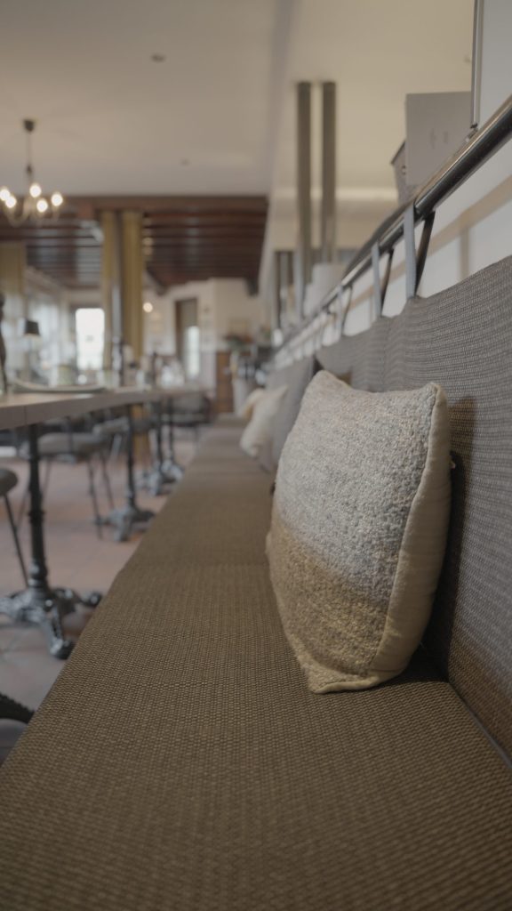 De bank langs de muur met kussens