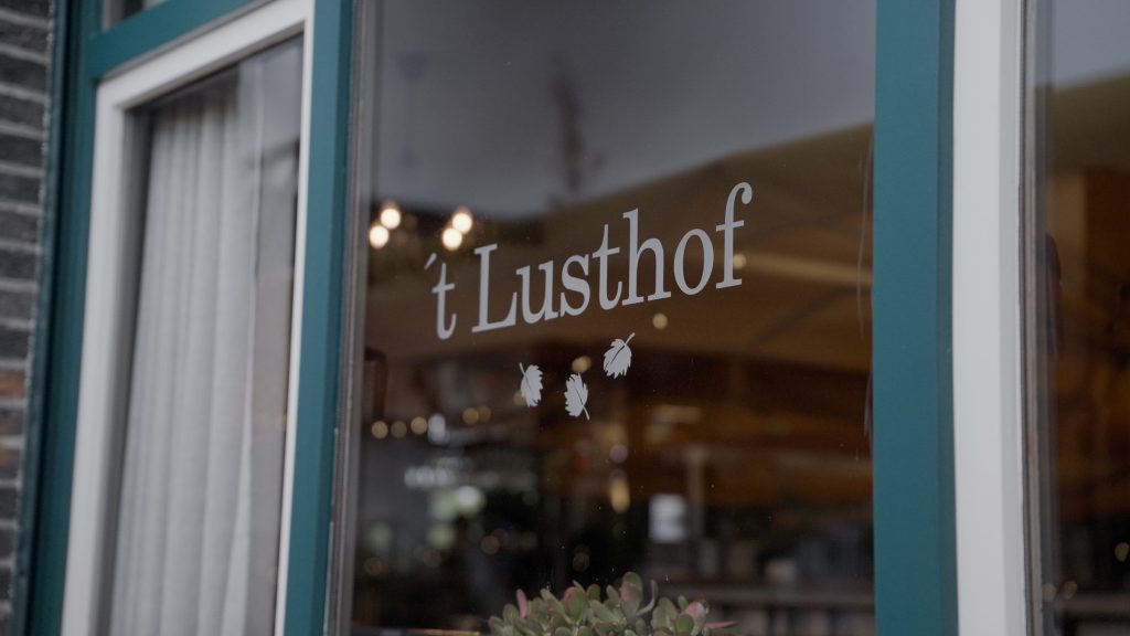 Het logo van 't Lusthof op het raam