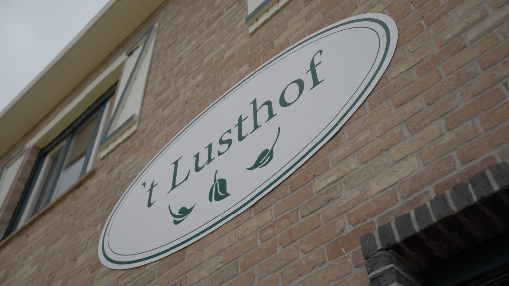 Het bord van 't Lusthof aan de gevel